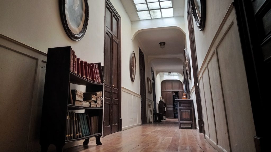 Foto de un pasillo amplio con libros y cuadros