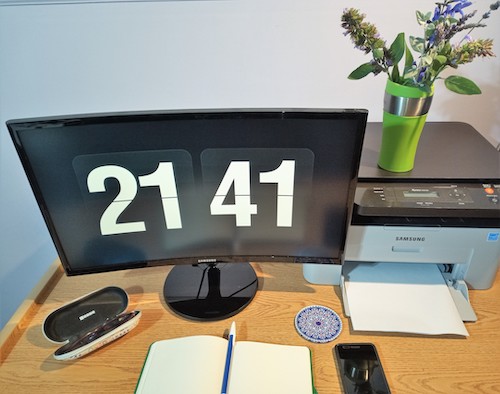 Foto de un escritorio. En el ordenador, la hora 21:41 con dígitos enormes