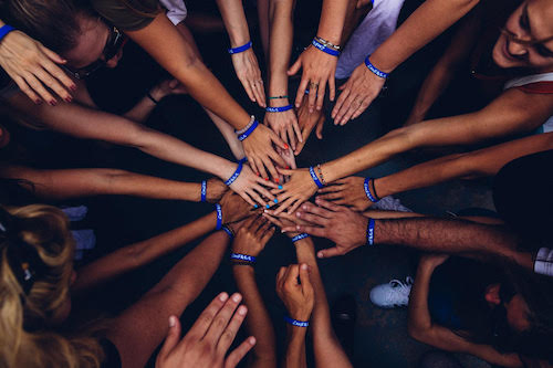Grupo de personas uniendo las manos en un mismo punto