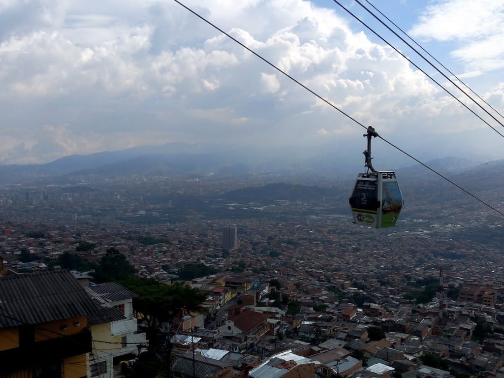 La ciudad de Medellín al fondo y el metrocable o teleférico en primer plano.