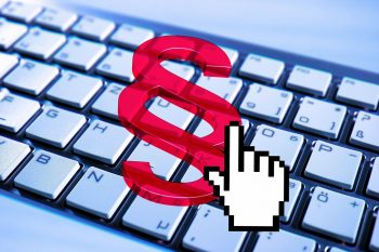 Símbolo de párrafo de color rojo y el icono de una mano con el dedo índice extendido sobre un teclado. 