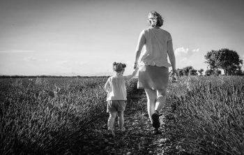 Una mujer y una niña caminando por el campo.