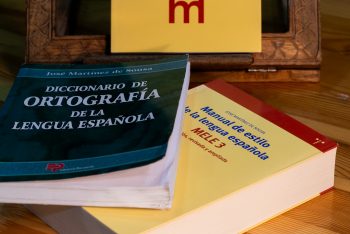 El Diccionario de ortografía de la lengua española y el Manual de estilo de la lengua española de José Martínez de Sousa sobre una mesa.